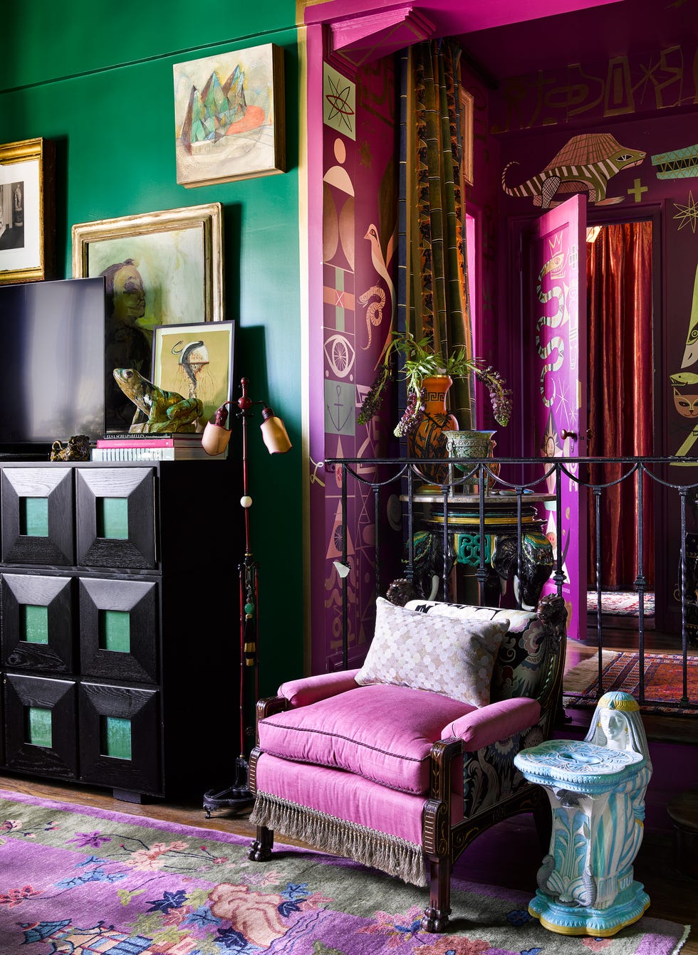Colorful interior setting with a vibrant pink chair and assorted decor.