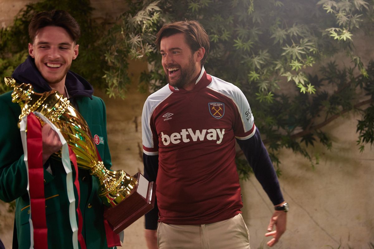 Jack Whitehall wearing a West ham shirt during the 2022 Mini Golf Challenge for Comic Relief on March 1,2022 in London, England. The 2022 Mini Golf Challenge for Comic Relief will see Arsenal fan and award-winning comedian, actor and presenter Jack Whitehall take on two England football heroes at the game of champions. Premier League players and childhood best friends Mason Mount and Declan Rice will be swapping their football clubs for golf clubs, as they go head-to-head on the mini golf course, with a big forfeit in store for the loser