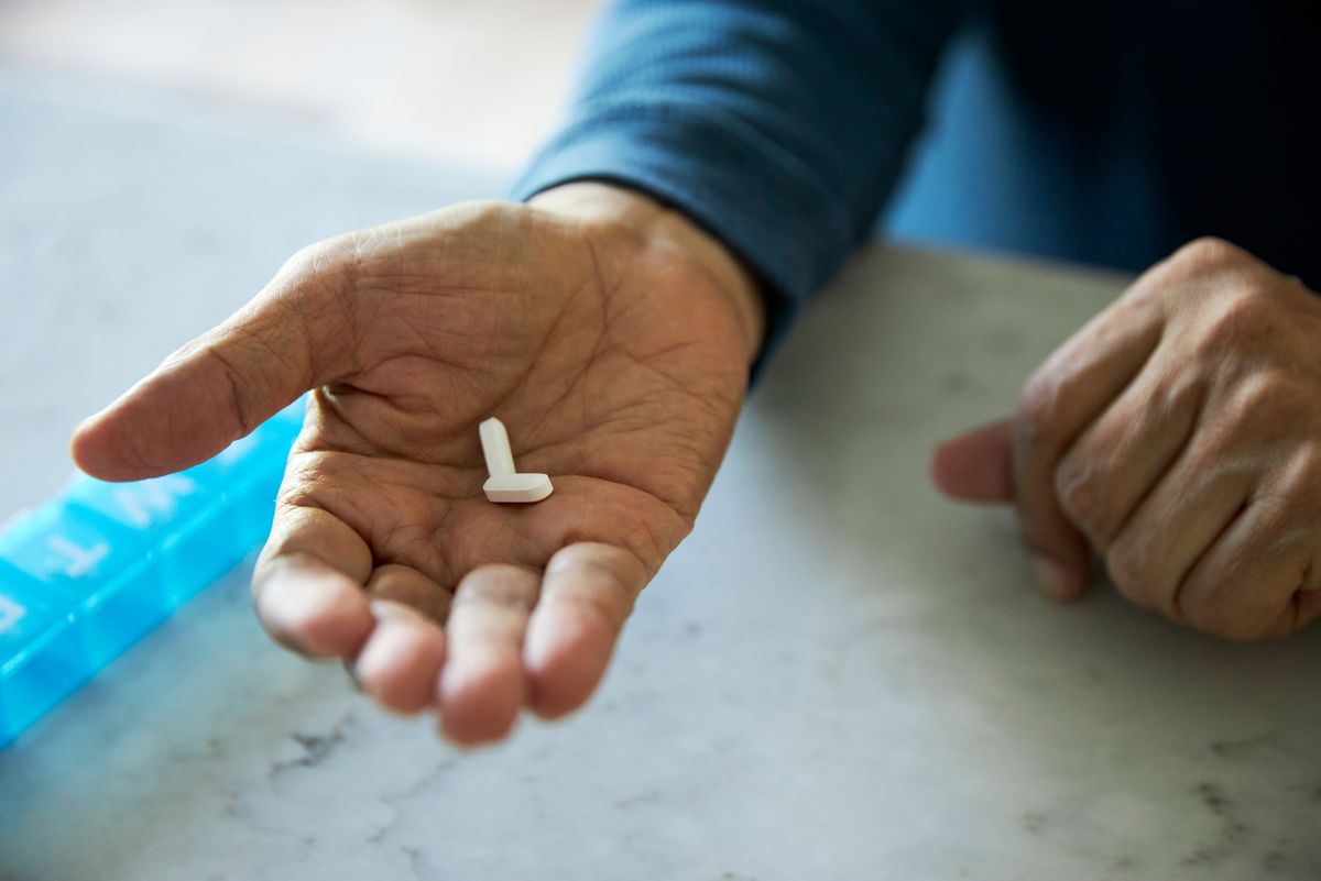 Man taking medication tablets