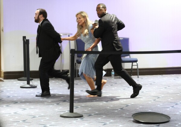 Guests are assisted and whisked away during the White House Correspondents Dinner, Saturday, April 25, 2026, in Washington. (AP Photo/Tom Brenner, File)