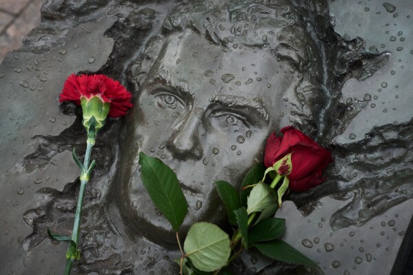 Red flowers lie on a bas-relief of firefighter Georgy Popov atop of his grave at the Mitinskoye Cemetery where several victims of the Chernobyl nuclear disaster are buried, marking the 40th anniversary of the explosion and fire at the Chernobyl nuclear power plant in Ukraine, outside Moscow, Sunday, April 26, 2026. (AP Photo/Alexander Zemlianichenko, File)