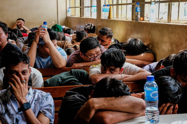 Detainees sit in a room after Ugandan authorities arrested dozens of foreigners in a crackdown on illegal migration in Kampala, Uganda, Tuesday, April 28, 2026. (AP Photo/Hajarah Nalwadda, File)