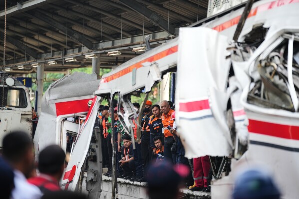 Workers and rescuers examine the wreckage following a train collision in Bekasi, Indonesia, Tuesday, April 28, 2026. (AP Photo/Tatan Syuflana, File)