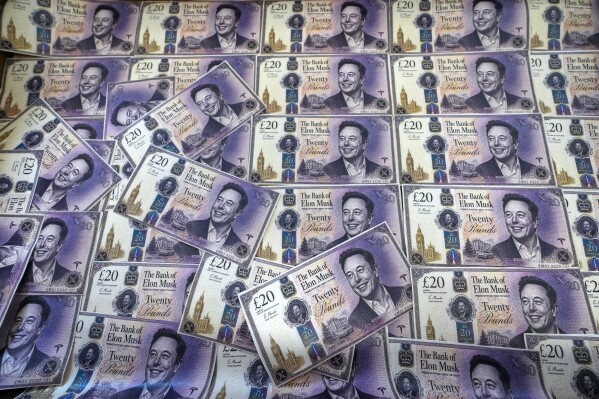 A suitcase of fake money decorated with the face of Elon Musk stands on a desk before Ed Davey, Leader of Britain's Liberal Democrat party, sets out his party's plan to 'protect our democracy and get Trump, Musk and Putin out of our politics' at a press conference in London, Wednesday, April 29, 2026. (AP Photo/Kirsty Wigglesworth, File)