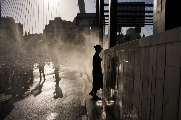Police use a water cannon to disperse ultra-Orthodox Jewish men blocking a street during a protest against army recruitment in Jerusalem, Wednesday, April 29, 2026. (AP Photo/Leo Correa, File)