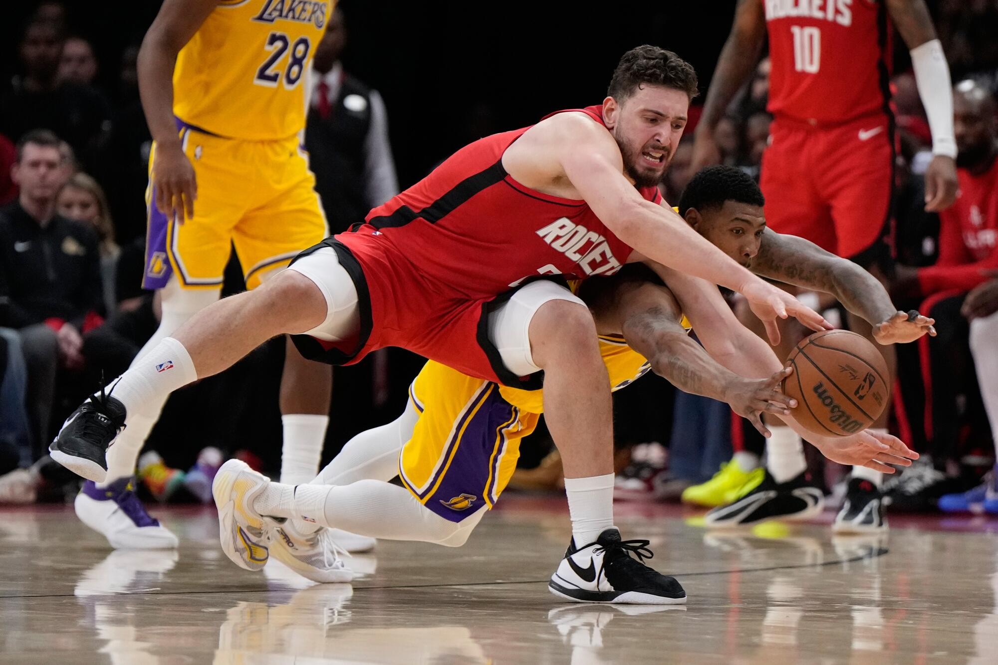 Lakers guard Marcus Smart dives behind Rockets center Alperen Sengun for a loose ball during the first half of Game 6.