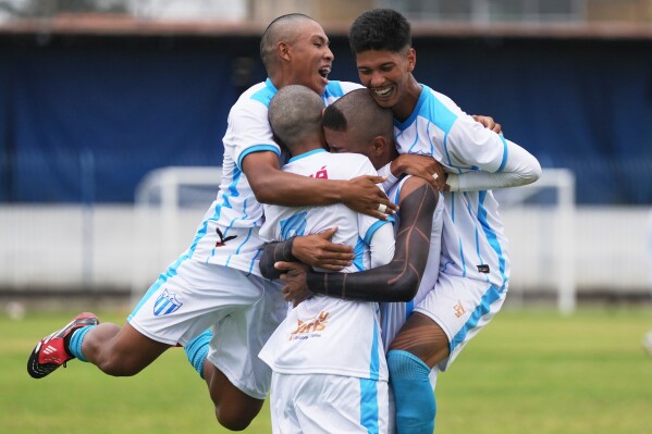 Players of Originarios, a new team in Rio's fifth division made up exclusively of Indigenous players, celebrate after scoring a goal against Barcelona during a Campeonato Carioca match in Rio de Janeiro, Sunday, May 3, 2026. (AP Photo/Silvia Izquierdo)