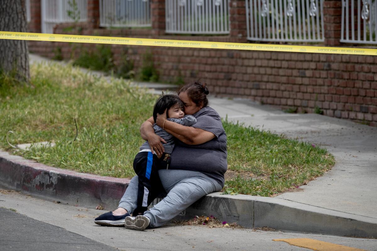 A woman hugs a child at the site where a roaming bear was captured Monday in the Hansen Dam neighborhood.