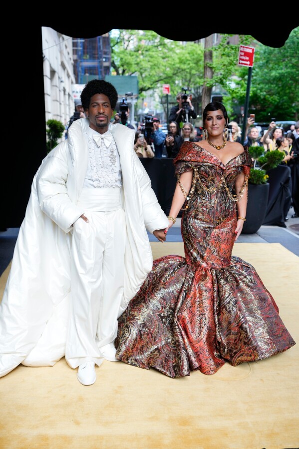 Jon Batiste, left, and Suleika Jaouad depart The Carlyle Hotel prior to attending The Metropolitan Museum of Art's Costume Institute benefit gala celebrating the opening of the "Costume Art" exhibition on Monday, May 4, 2026, in New York. (Photo by Charles Sykes/Invision/AP)