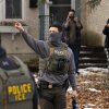 In this photo, two observers holding up smartphones stand in the background as they record two Immigration and Customs Enforcement agents in Minneapolis on February 5.