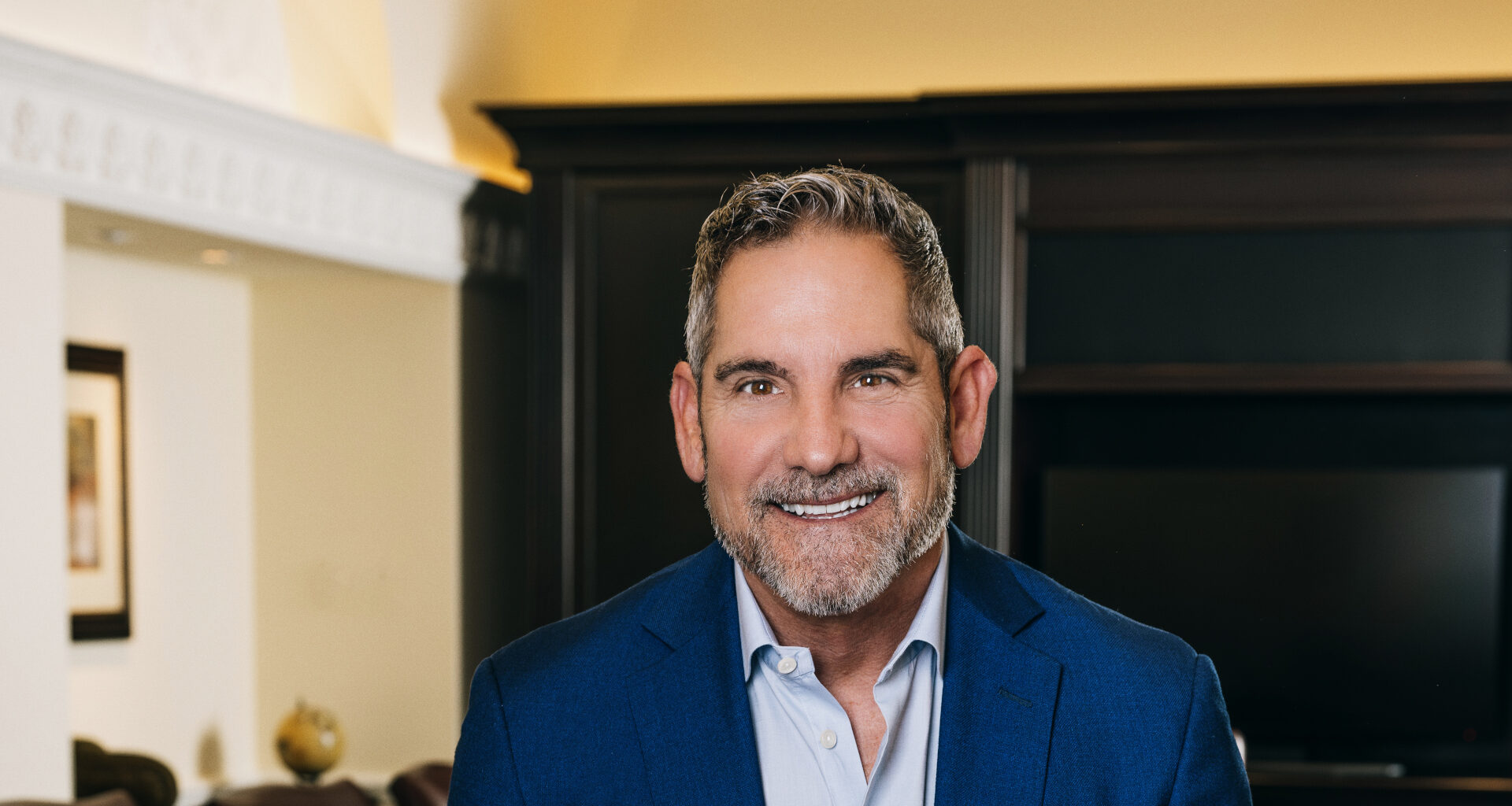Grant Cardone smiling at the camera in a board room.