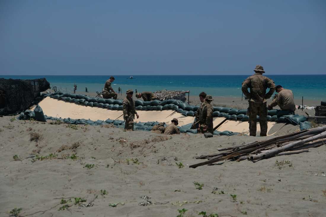 Soldiers of the U.S. Army's 25th Infantry Division build fighting positions with sandbags along the beach of the La Paz sand dunes in Laoag City, Philippines.