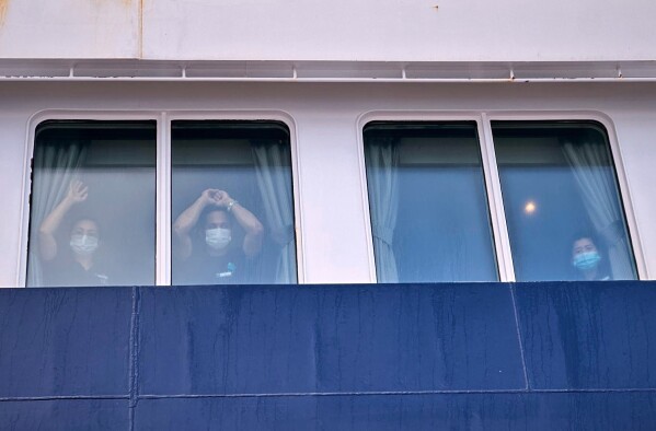 Passengers watch as others are disembarked from the hantavirus-stricken cruise ship MV Hondius at the port of Granadilla in Tenerife, Canary Islands, Spain, Sunday, May 10, 2026. (AP Photo)