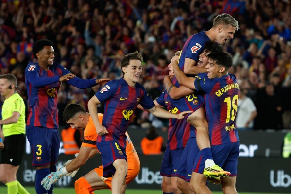 Barcelona players celebrate after winning the Spanish La Liga soccer match between FC Barcelona and Real Madrid that makes them Spanish league champions in Barcelona, Spain, Sunday, May 10, 2026. (AP Photo/Joan Monfort)