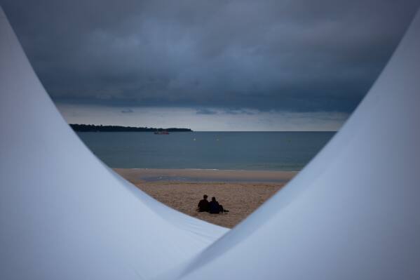 People sit on the beach ahead of the 79th Cannes international film festival Sunday, May 10, 2026, in Cannes, southern France. (AP Photo/John Locher)