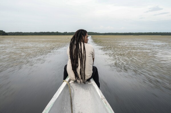 Jhon Cantillo, a local environmental and social leader, poses for a photo as he travels through an invasive plant called a Hydrilla verticillata Thursday, April 30, 2026, on the outskirts of Buenavista, Colombia. (AP Photo/Ivan Valencia)
