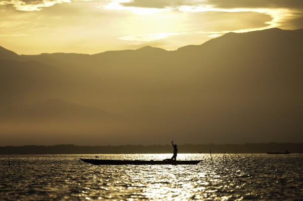 A fisherman throws his net to fish Thursday, April 30, 2026, on the outskirts of Cienaga, Colombia. (AP Photo/Ivan Valencia)