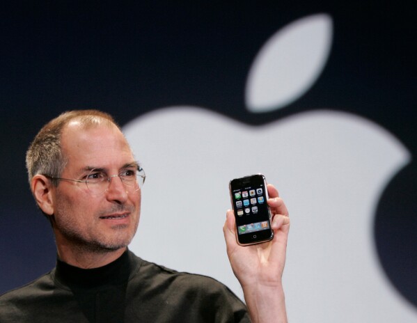 Apple CEO Steve Jobs holds up an Apple iPhone at the MacWorld Conference in San Francisco on Jan. 9, 2007. (AP Photo/Paul Sakuma, File)