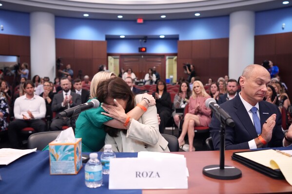 Roza, center, a survivor of convicted sex trafficker Jeffrey Epstein's abuses, is comforted by fellow survivor Dani Hannah Bensky, as she is overcome with emotion after addressing House Oversight Committee Democrats at a field hearing focused on the Epstein Investigation, Tuesday, May 12, 2026, in West Palm Beach, Fla. (AP Photo/Rebecca Blackwell)