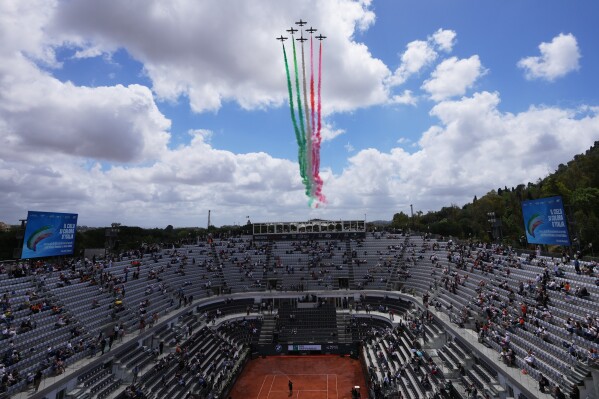 The Frecce Tricolori (Tricolor Arrows) Italian Air Force acrobatic squad fly above the Foro Italico as tribute to late Italian tennis legend Nicola Pietrangeli commemorated during the Italian Open tennis tournament in Rome, Tuesday, May 12, 2026. (AP Photo/Alessandra Tarantino)