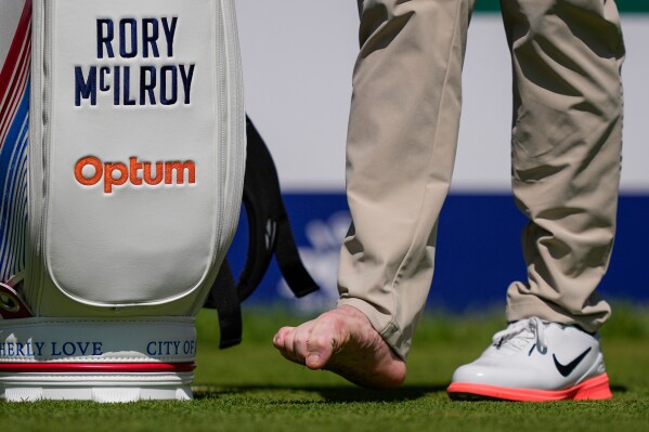 Rory McIlroy, of Northern Ireland, attends to his right foot on the fourth tee during a PGA Championship golf tournament practice round at Aronimink Golf Club, Tuesday, May 12, 2026, in Newtown Square, PA. (AP Photo/Matt Slocum)