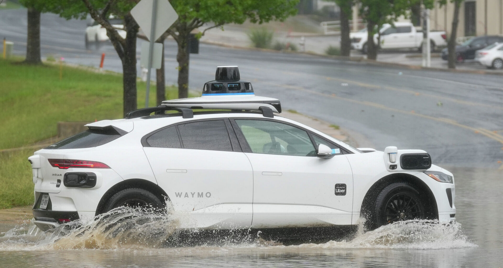 A Waymo autonomous vehicle goes through standing water on Metro Center Drive after a brief, intense rainstorm April 30 in Austin.