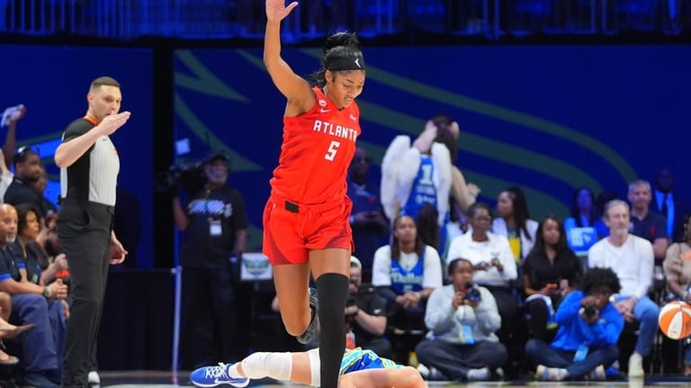 Atlanta Dream forward Angel Reese (5) jumps over a fallen...