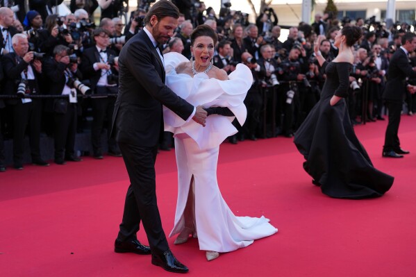 Laurent Lafitte, left, and Joan Collins pose for photographers at the opening ceremony and premiere of the film 'The Electric Kiss' during 79th international film festival, Cannes, southern France, Tuesday, May 12, 2026. (AP Photo/Andreea Alexandru)