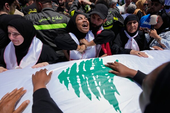 Mourners react over the coffin of Lebanese Civil Defense member, Ahmad Noura, who was killed the previous day in an Israeli airstrike during a funeral procession in the coastal city of Sidon, Lebanon, Wednesday, May 13, 2026. (AP Photo/Mohammed Zaatari)