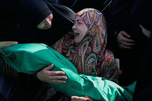 Women grieve as they hold the body of 6-month-old Mariam Fahos, killed a day earlier in an Israeli airstrike in the village of Saksakieh, during a funeral procession in the southern port city of Sidon, Lebanon, Sunday, May 10, 2026. (AP Photo/Mohammed Zaatari)