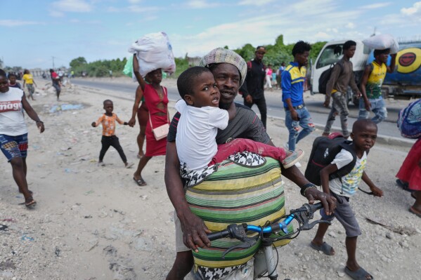 Residents flee their homes to escape clashes between armed gangs in Port-au-Prince, Haiti, Monday, May 11, 2026. (AP Photo/Odelyn Joseph)