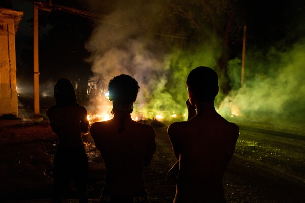 People look at a barricade set up by residents protesting against prolonged power outages in Havana, Cuba, Wednesday, May 13, 2026. (AP Photo/Ramon Espinosa)