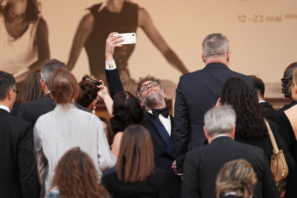 Seth Rogen takes a selfie photograph upon arrival at the premiere of the film 'Fatherland' at the 79th international film festival, Cannes, southern France, Thursday, May 14, 2026. (Photo by Scott A Garfitt/Invision/AP)