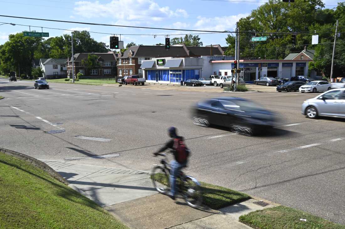 A bicyclist and motorists make their way down Poplar Ave. at the McLean Blvd. intersection on Sept. 8, 2022, in Memphis, Tenn.