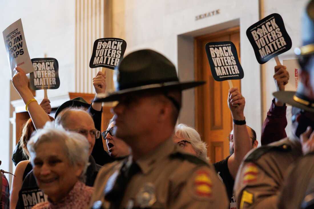 Demonstrators hold "Black Voters Matter" signs behind a law enforcement officer during a special legislative session at the Tennessee State Capitol in Nashville, Tenn., on May 7.