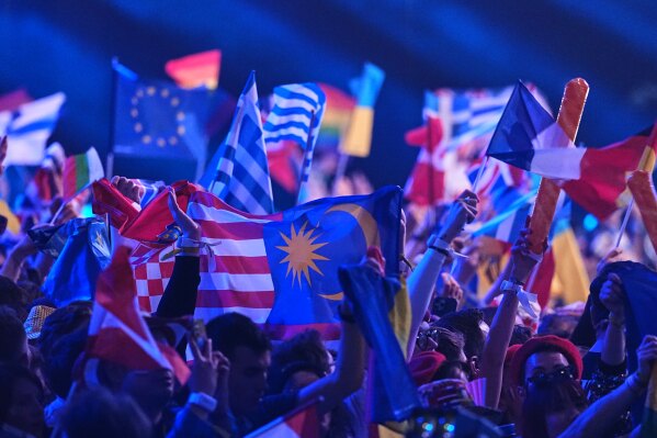 Spectators wave flags before the Grand Final of the 70th Eurovision Song Contest in Vienna, Austria, Saturday, May 16, 2026. (AP Photo/Martin Meissner)