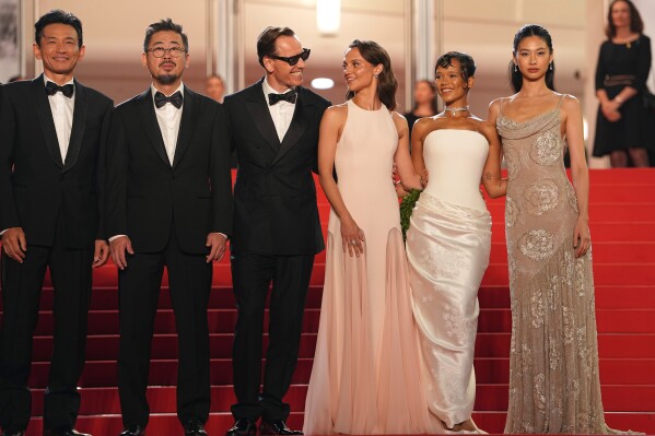 Hwang Jung-min, from left, director Na Hong-jin, Michael Fassbender, Alicia Vikander, Taylor Russell, and Hoyeon pose for photographers upon arrival at the premiere of the film 'Hope' at the 79th international film festival, Cannes, southern France, Sunday, May 17, 2026. (AP Photo/Andreea Alexandru)