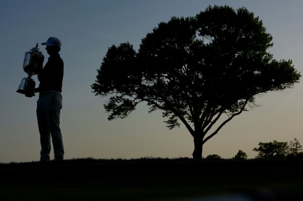 Aaron Rai, of England, holds the Wanamaker Trophy after winning the PGA Championship golf tournament at Aronimink Golf Club, Sunday, May 17, 2026, in Newtown Square, PA. (AP Photo/Carolyn Kaster)