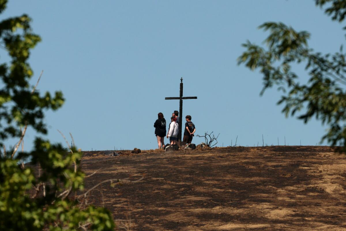 Four people standing in the distance at the top of a slope