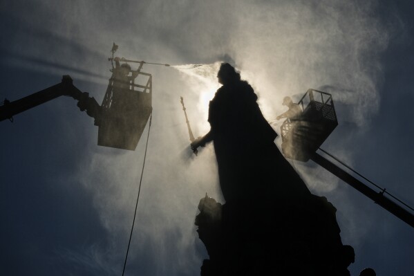 Employees of the Museum of Urban Sculpture clean the statue of Russian Tsarina Catherine the Great in St. Petersburg, Russia, Tuesday, May 19, 2026. (AP Photo/Dmitri Lovetsky)