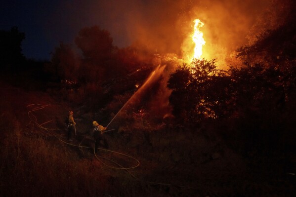 Fire crews conduct a firing operation to control the Sandy Fire, Monday, May 18, 2026, in Simi Valley, Calif. (AP Photo/Ethan Swope)