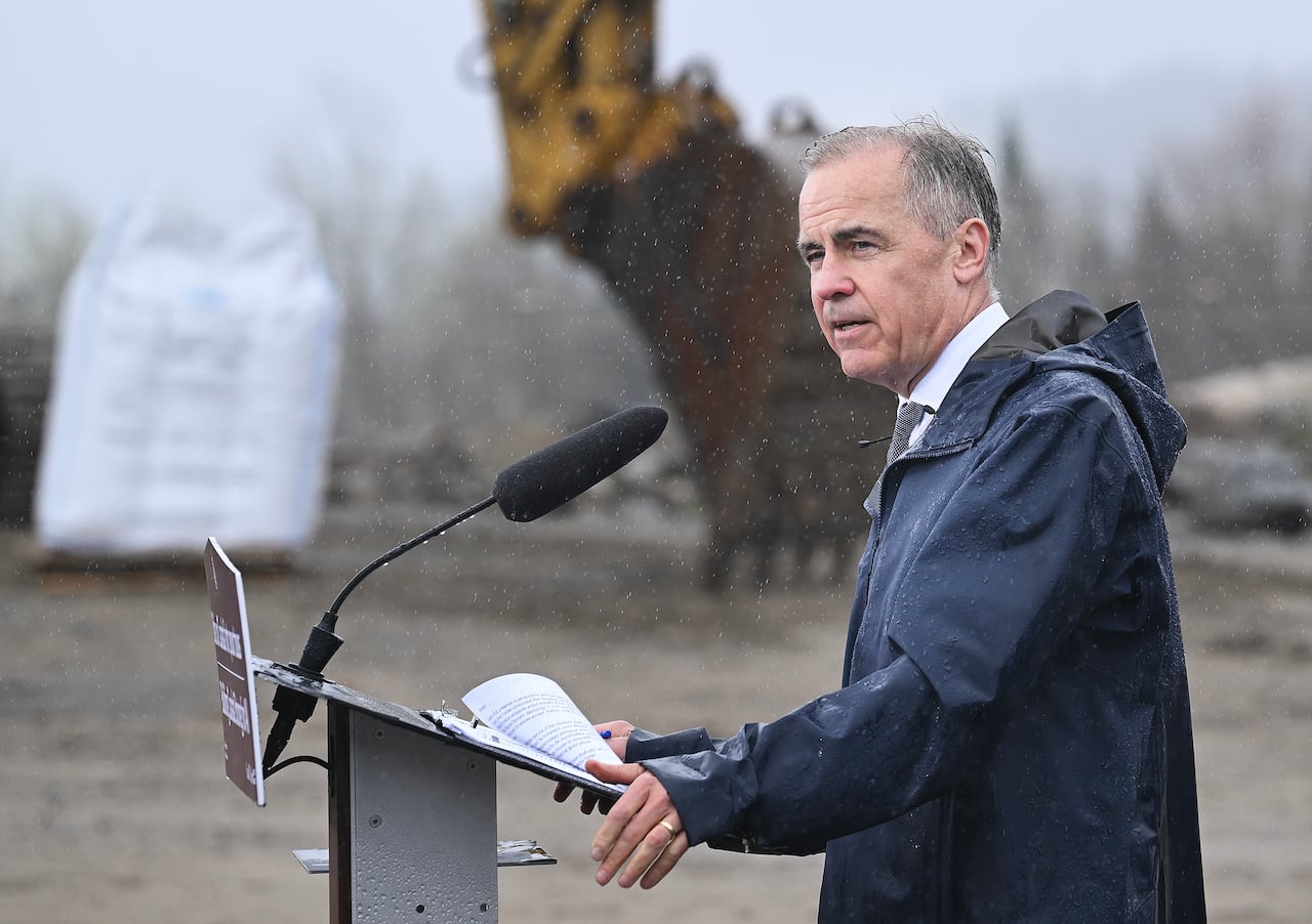 Man wearing dark raincoat standing at podium