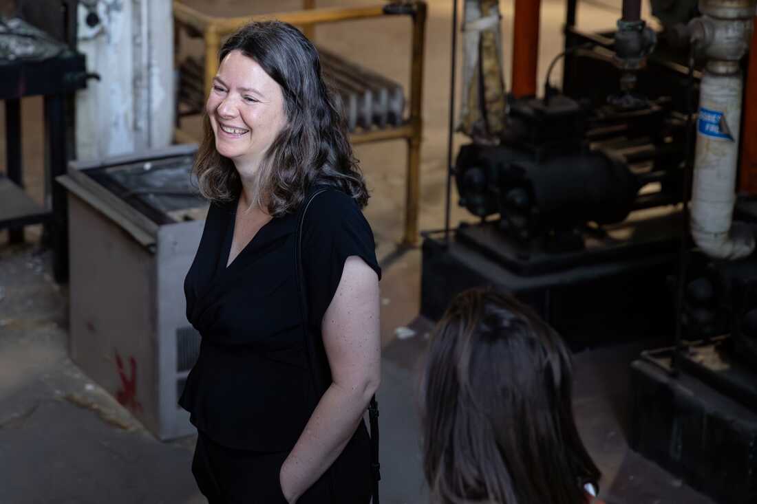 Elizabeth Babcock stands in the old Cherokee Boiler House, near industrial-looking equipment.