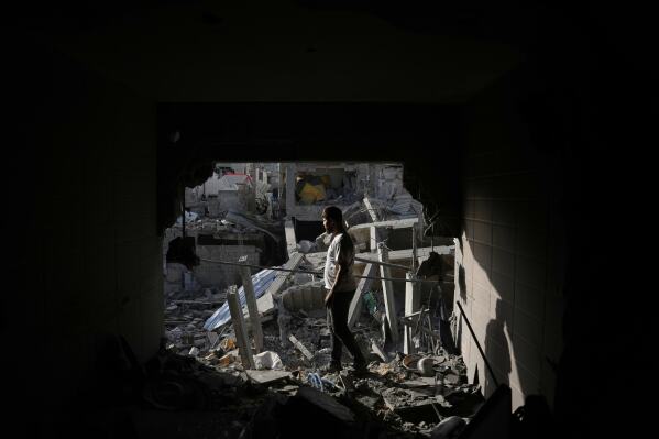Palestinians inspect the rubble of the Abu Shamala family home, destroyed in Israeli airstrike at the Bureij refugee camp in the central Gaza Strip Wednesday, May 20, 2026. (AP Photo/Abdel Kareem Hana)