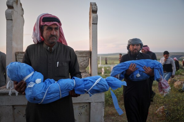 The bodies of Ryan Al-Fanikh, left, and Aya Al-Fanikh, whom relatives said were killed by an explosion caused by war remnants while they were playing in the village of Abu Habbah in eastern Idlib countryside, are carried during their funeral in Abu Habbah, Syria, Thursday, May 21, 2026. Another child was also killed and four others wounded.(AP Photo/Ghaith Alsayed)