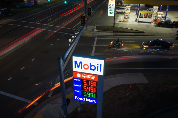 In this photo taken with a slow shutter speed, traffic moves past a sign for a Mobil gas station on Wednesday, April 29, 2026, in Portland, Ore. (AP Photo/Jenny Kane)
