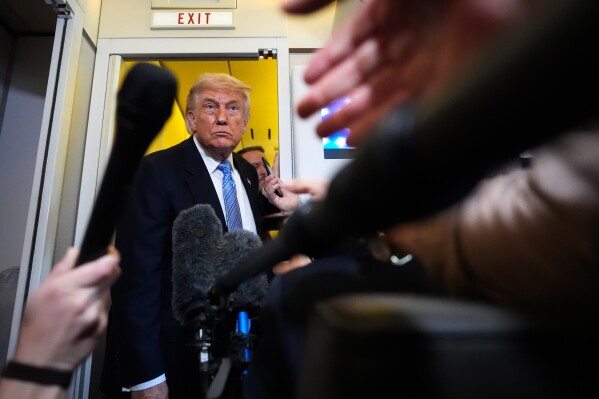 President Donald Trump speaks to reporters aboard Air Force One, Friday, May 15, 2026, as he returns from a trip to Beijing, China. (AP Photo/Mark Schiefelbein)