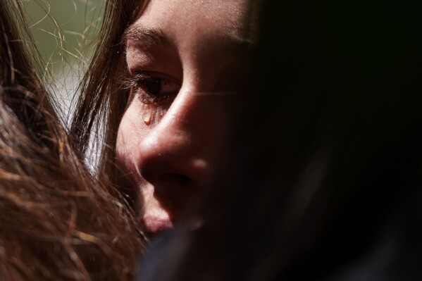 A teenage girl cries near a heavily damaged house after a Russian strike on a residential neighbourhood in Kyiv, Ukraine, Friday, May 15, 2026. (AP Photo/Evgeniy Maloletka)