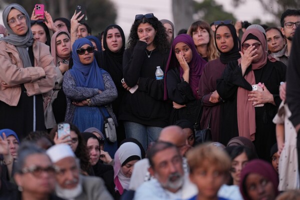 Attendees react as they listen to a speech during a vigil, the day after a shooting, outside of the Islamic Center of San Diego, Tuesday, May 19, 2026, in San Diego. (AP Photo/Jae C. Hong)