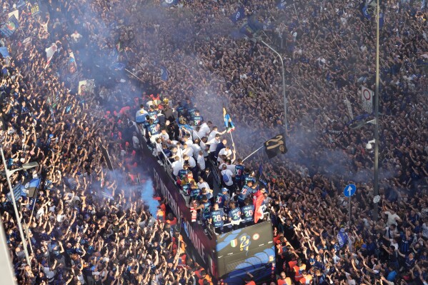 Thousands of fans cheer as a bus carries the triumphant Inter Milan soccer team players outside the San Siro stadium, celebrating their 21th Italian Serie A top league title after a Serie A soccer match between Inter Milan and Hellas Verona, in Milan, Italy, Sunday, May 17, 2026. (AP Photo/Luca Bruno/Pool)